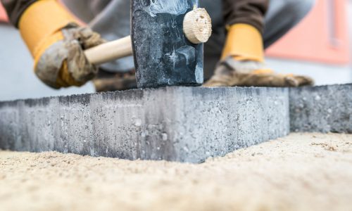 builder-tamping-down-a-new-paving-slab-or-brick-D394C2U builder-tamping-down-a-new-paving-slab-or-brick-D394C2U